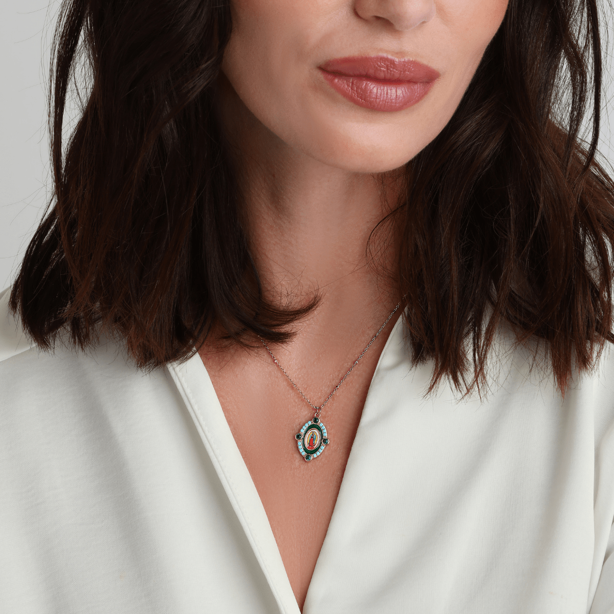 Emerald Our Lady of Guadalupe necklace styled with gold jewelry