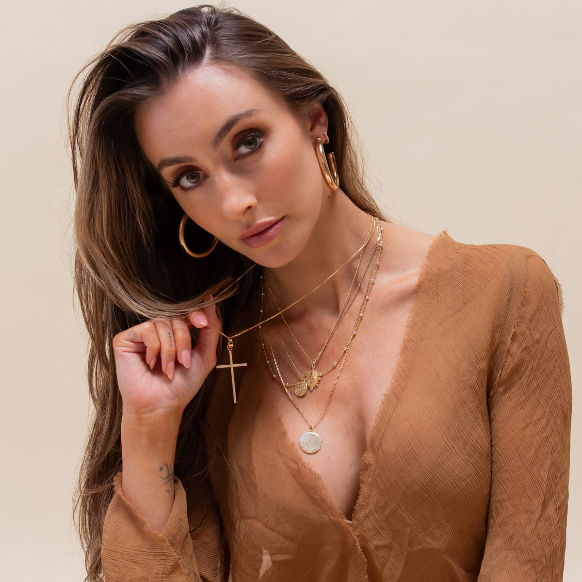 Vigil Cross necklace styled with layered gold jewelry