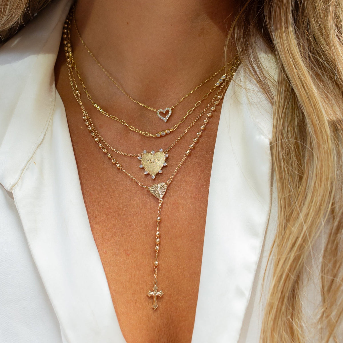Heart of Devotion gold rosary styled on a model
