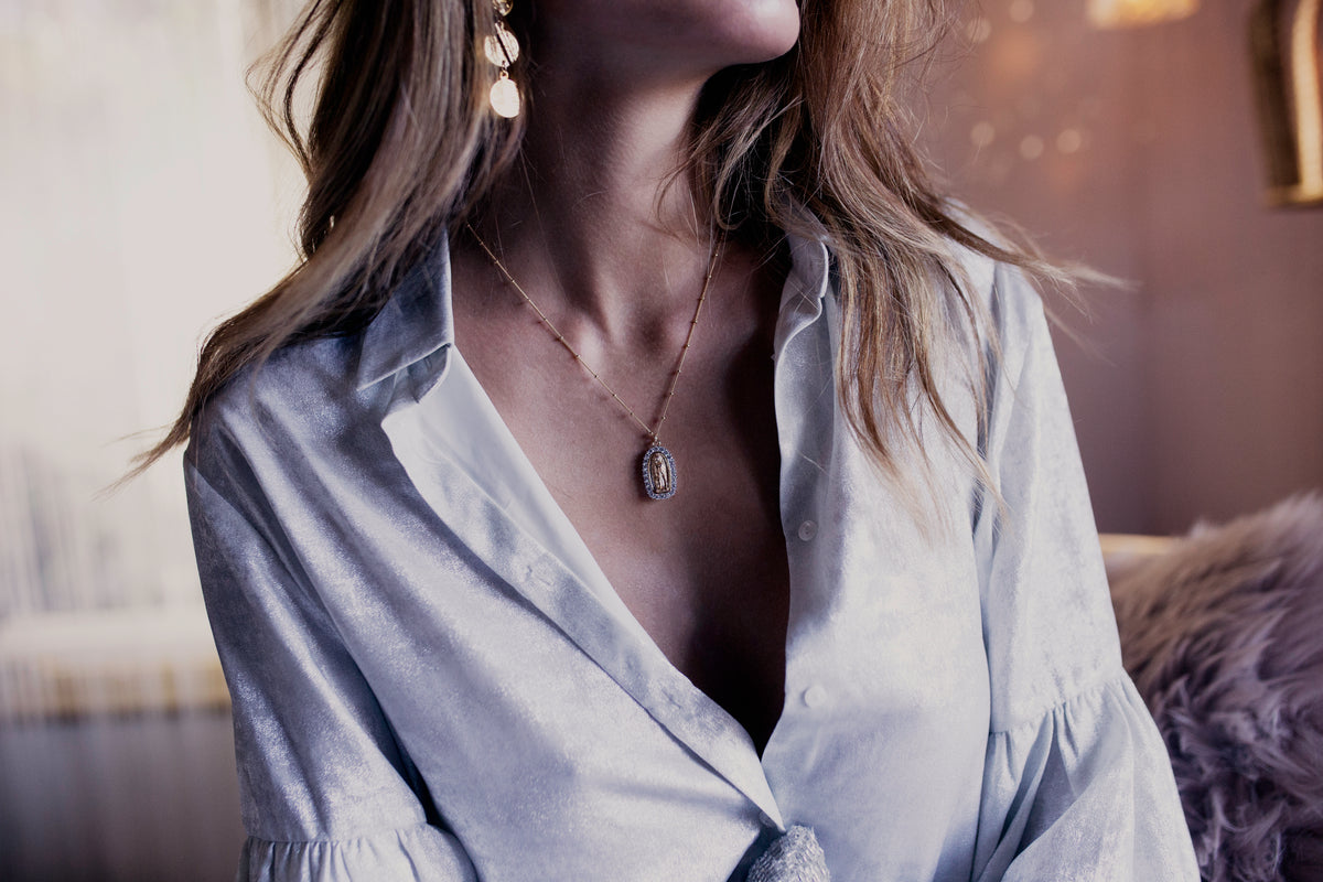 Heirloom necklace styled with layered gold jewelry