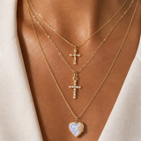 Joy Dravecky layered gold necklace styling with heart and cross pendants
