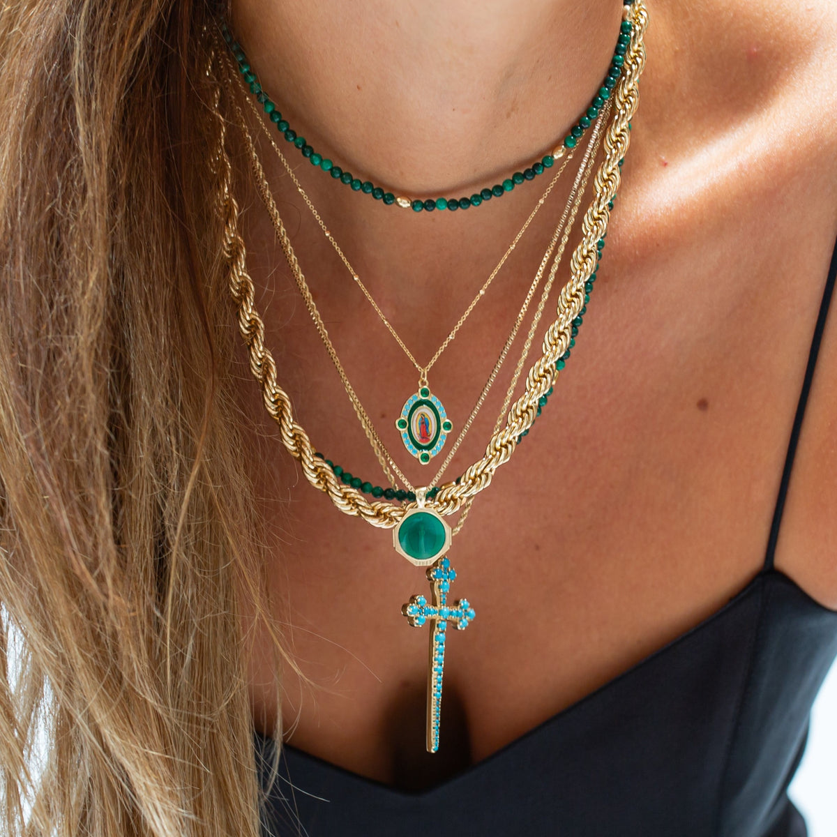 Athena Cross turquoise necklace styled with layered gold jewelry